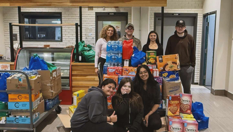 Students in the PSI/PF Society show off some of the food items collected