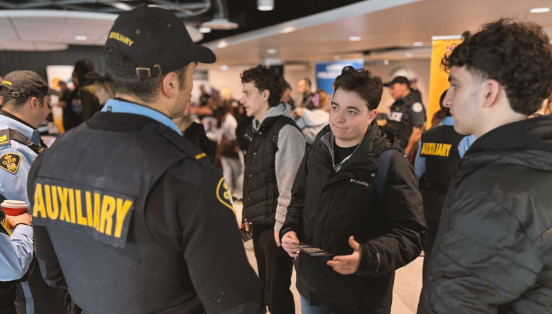 St. Clair College students engage with an auxiliary police officer at the First Responders Career Fair