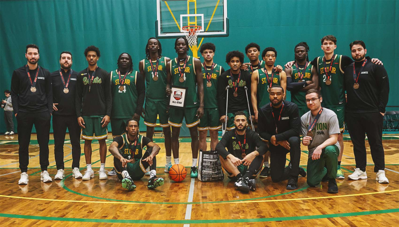 Saints Men's Basketball team poses with bronze medals