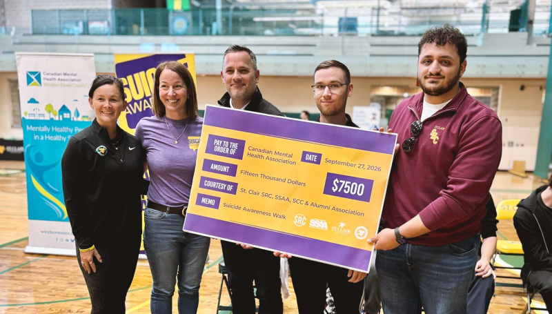 Lori Kempe, Nicole Sbrocca, St. Clair College President Michael Silvaggi, Robbie Durling and Ali Hadwan pose with a $7,500 cheque for CMHA Windsor-Essex County at the annual Suicide Awareness Walk