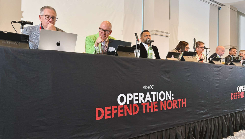 Panel of speakers at table with microphones