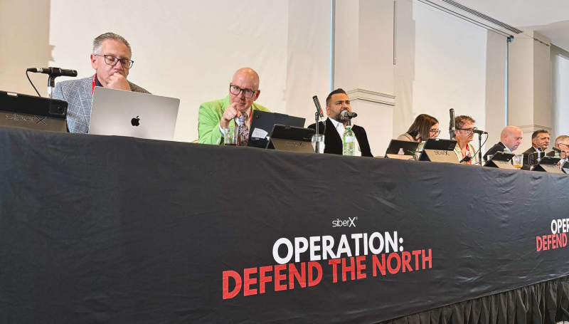 Panel of speakers at table with microphones