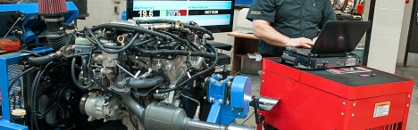 Car engine being diagnosed on computer.