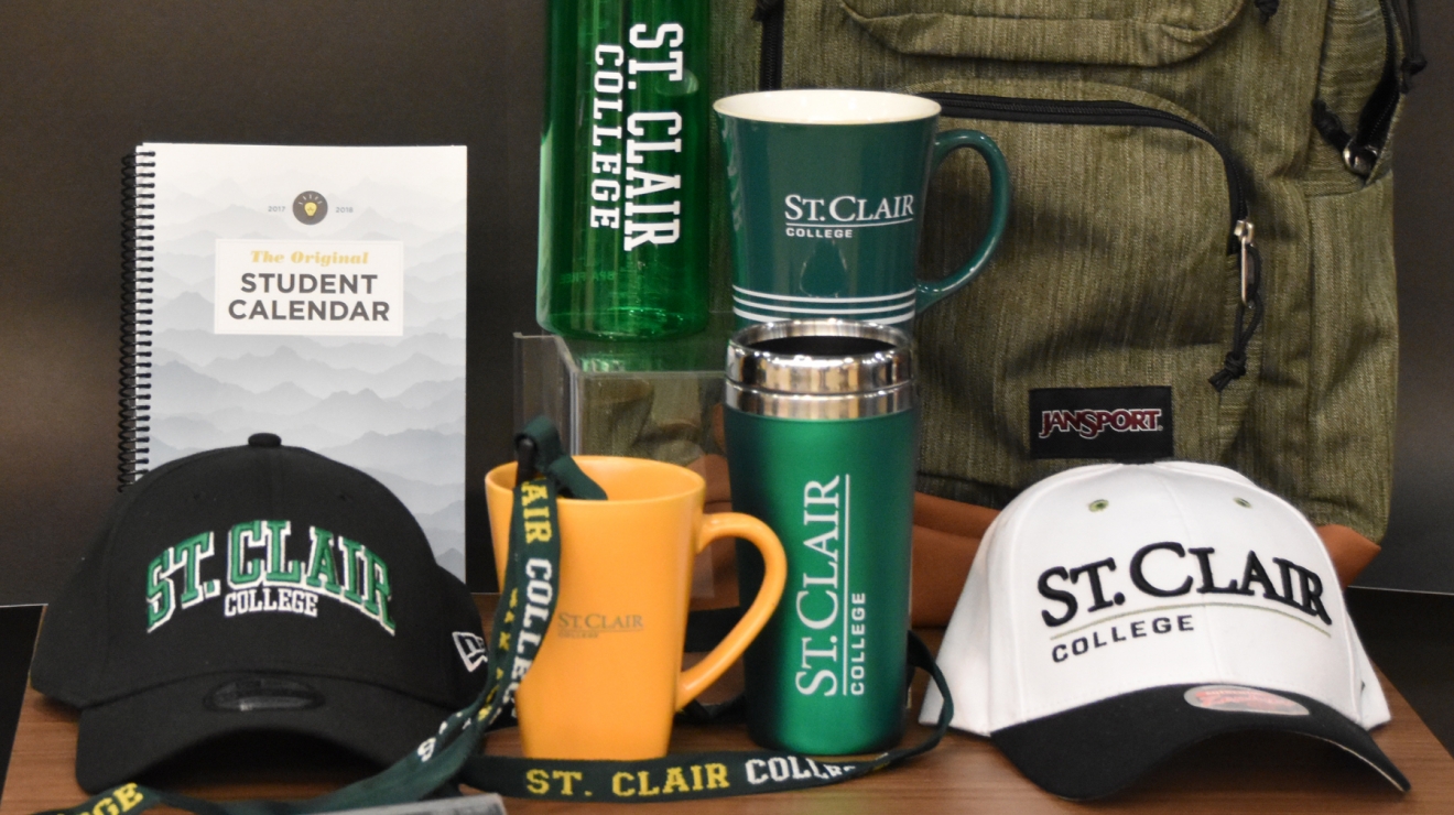 Backpack, mugs, bottles, books and hats on table