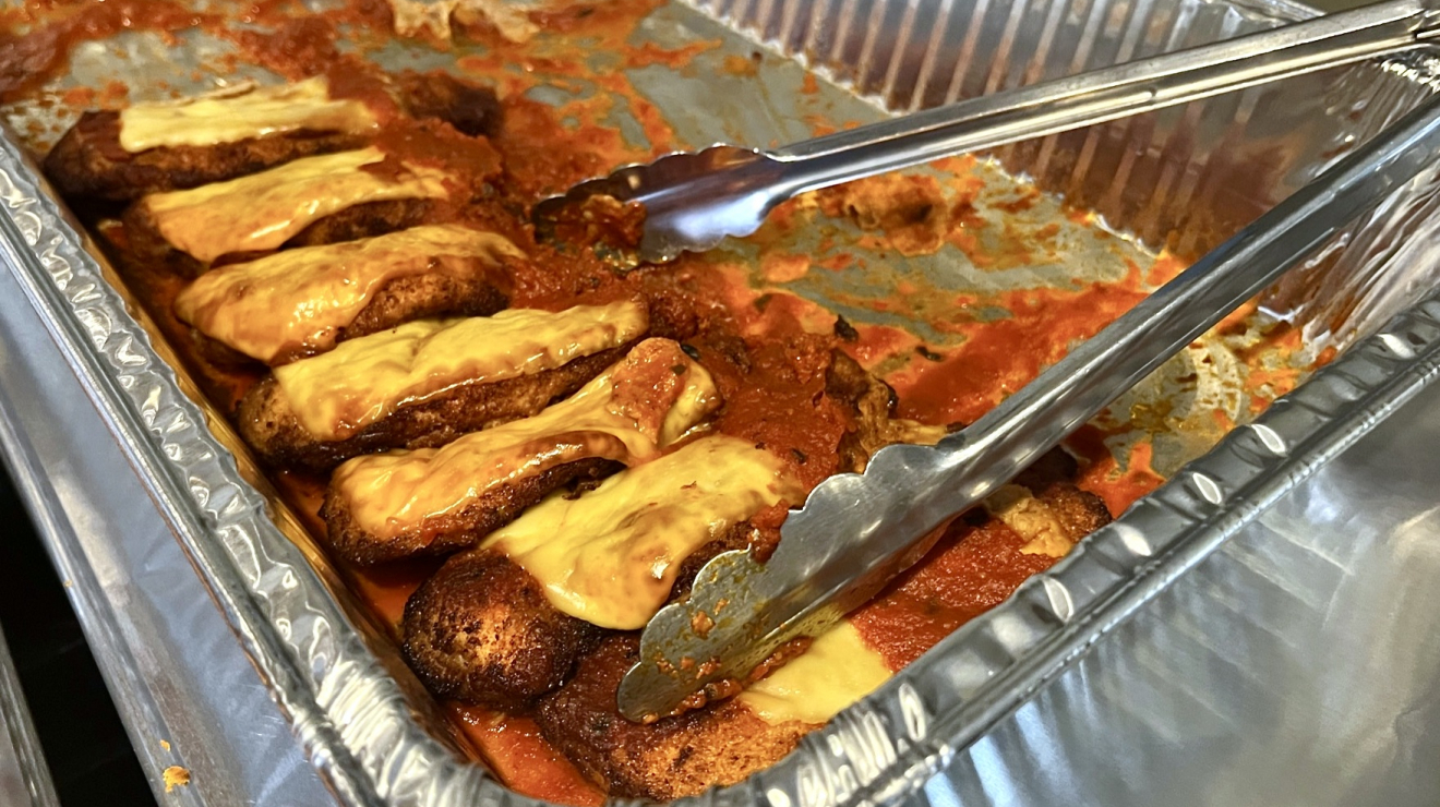 Some kind of food in tray with cheese on it