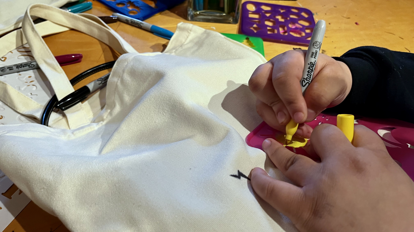 Someone decorating bag with stencils
