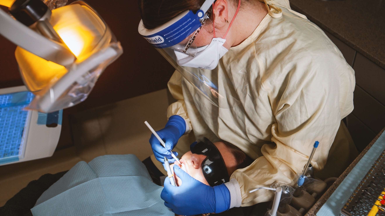 Hygienist cleaning the teeth of a patient