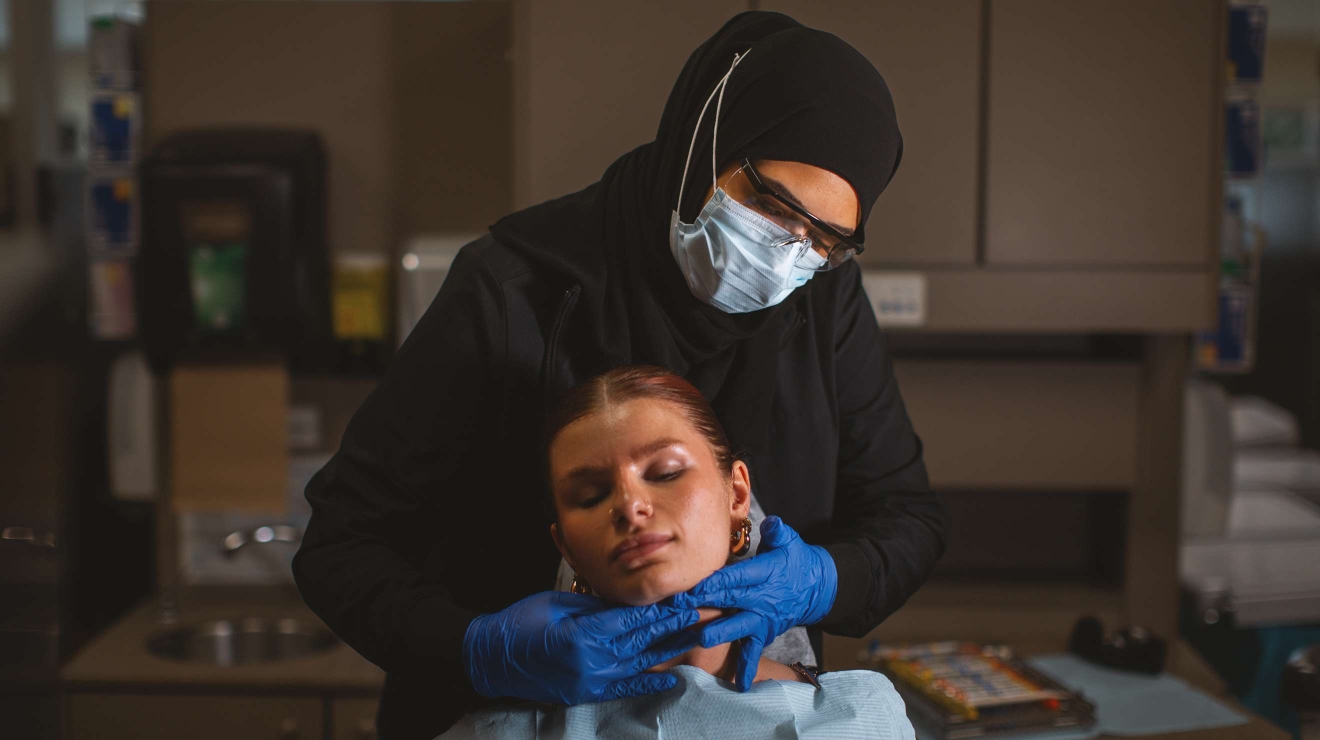 Hygienist checking the lymph nodes of a patient